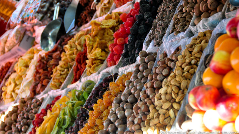 Close-up of colorful piles of dried fruits and nuts arranged in a market display near the Great Wall visitor area.