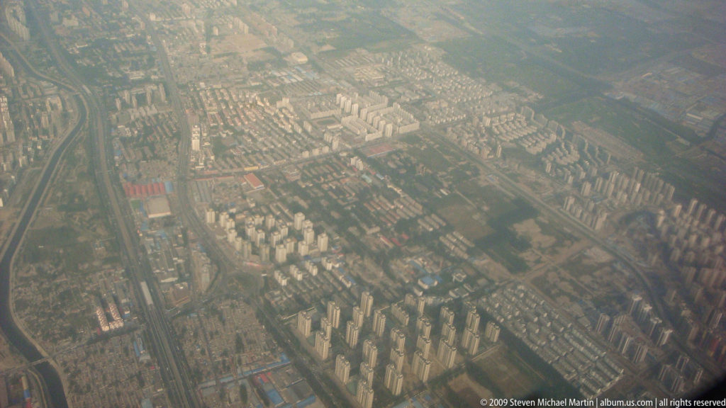 Aerial view of dense apartment towers and roads spreading across a hazy urban area near Guilin in southern China.