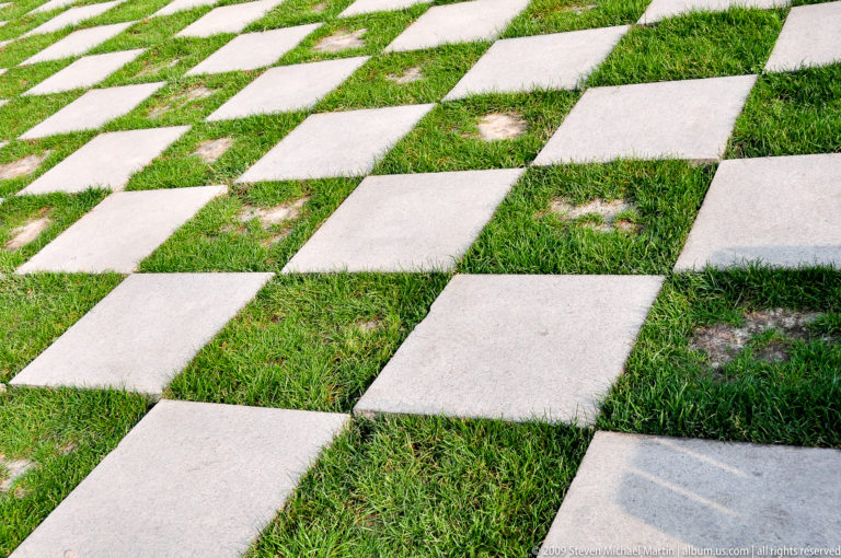Checkerboard walkway of pale stone slabs alternating with green grass at the Mausoleum of the First Qin Emperor near Xi'an.