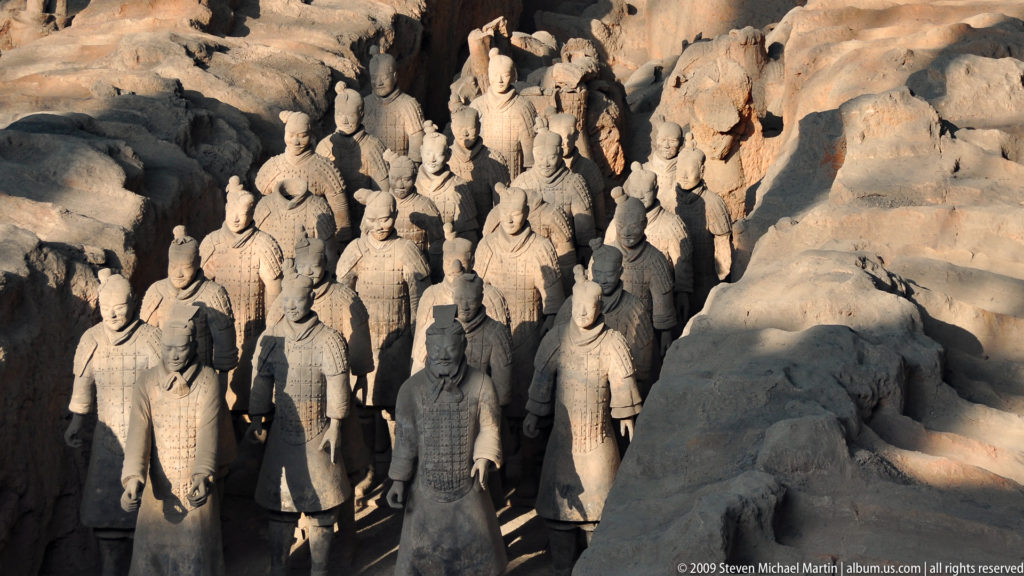 Rows of terracotta infantry warriors standing in a narrow earthen excavation trench at the Mausoleum of the First Qin Emperor near Xi’an.