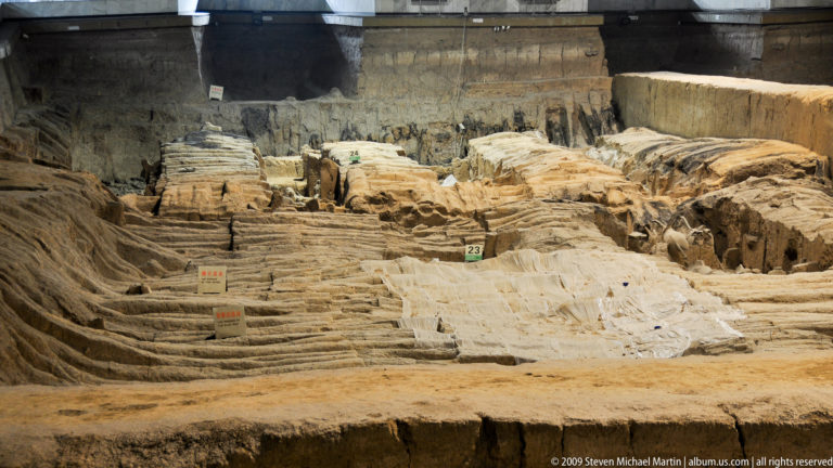 Exposed earthen and brick structural remains in archaeological excavation trenches at the Mausoleum of the First Qin Emperor near Xi'an.