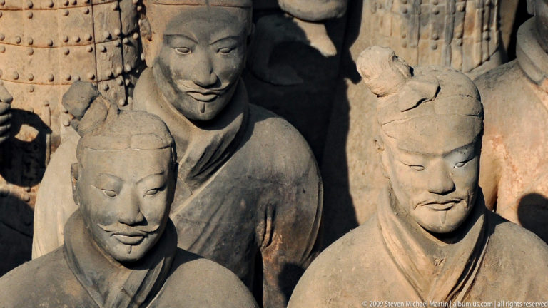 Close view of two individualized terracotta warrior heads with distinct moustaches and hairstyles from the Mausoleum of the First Qin Emperor near Xi'an.