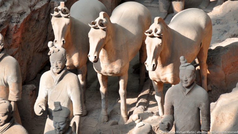 Terracotta horses with standing attendants or cavalry figures in an excavation trench at the Mausoleum of the First Qin Emperor near Xi'an.