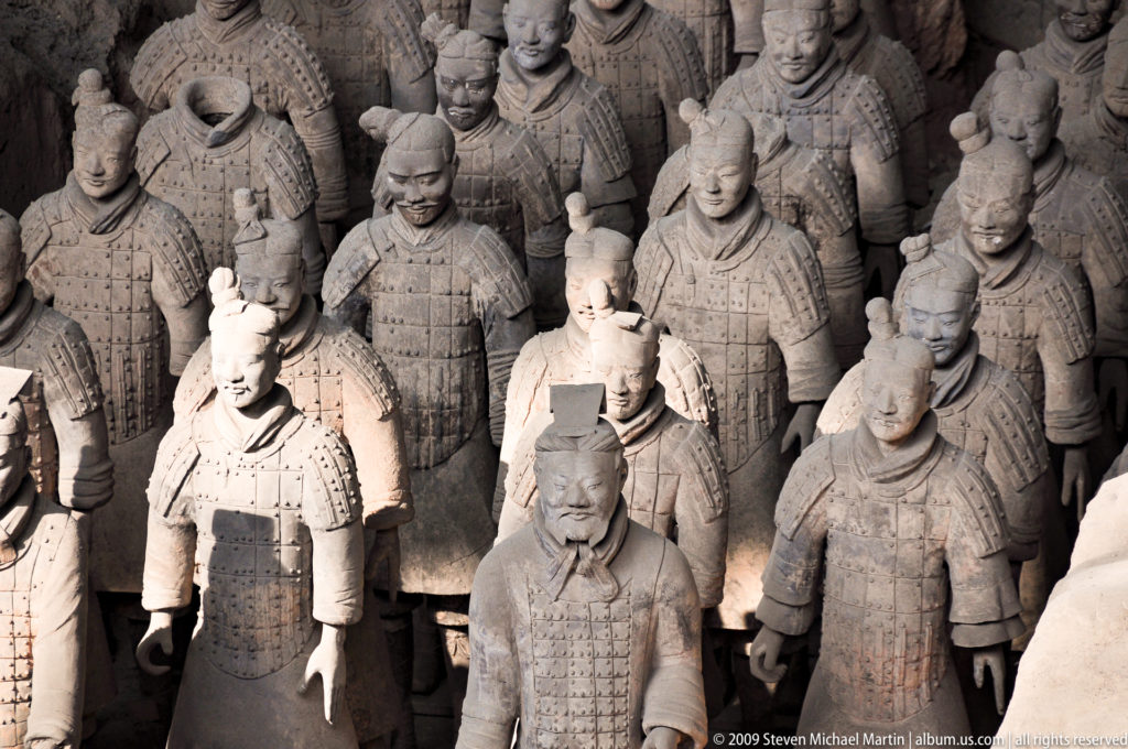 High-angle view of densely ranked terracotta infantry with alternating armored and robed warriors at the Mausoleum of the First Qin Emperor near Xi’an.