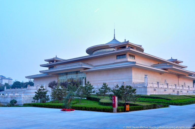 Exterior view of the Shaanxi History Museum in Xi’an, showing a large symmetrical building with stone terraces and a central roof inspired by Tang-dynasty architecture.