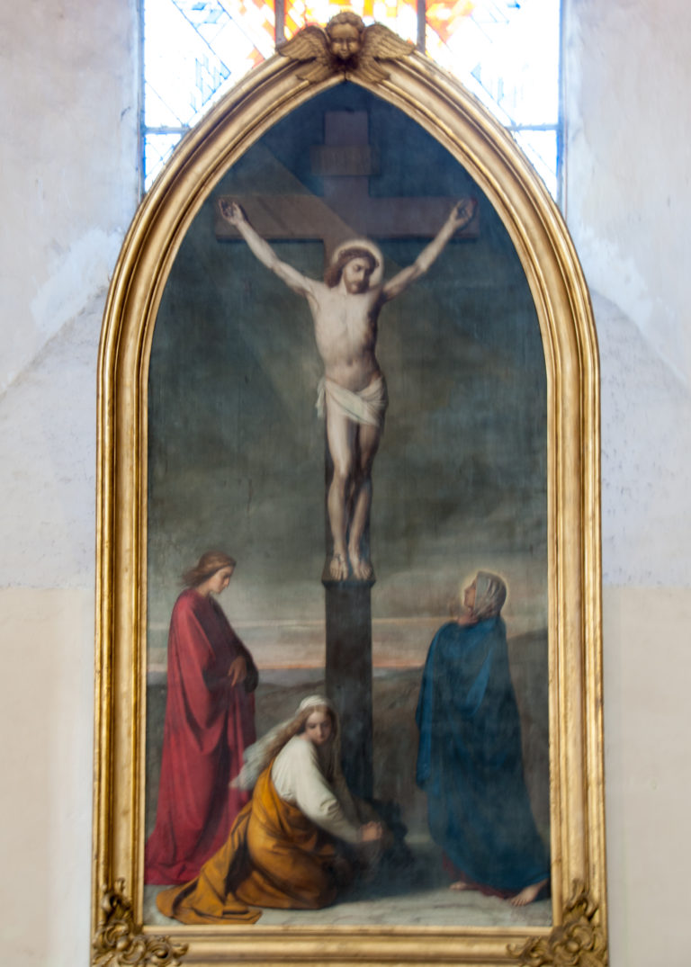 Arched framed painting of the Crucifixion with Christ on the cross above mourning figures in red, yellow and blue robes.
