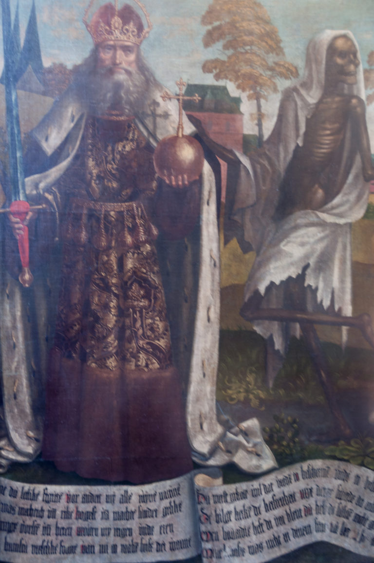 Ornately robed male figure beside a shrouded skeleton in the Dance of Death, with Low German text running below.