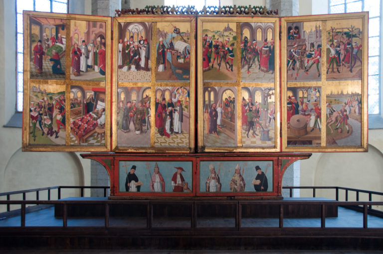 Half-open high-altar retable by Hermen Rode’s workshop, with rows of painted narrative scenes above the predella in St Nicholas Church.