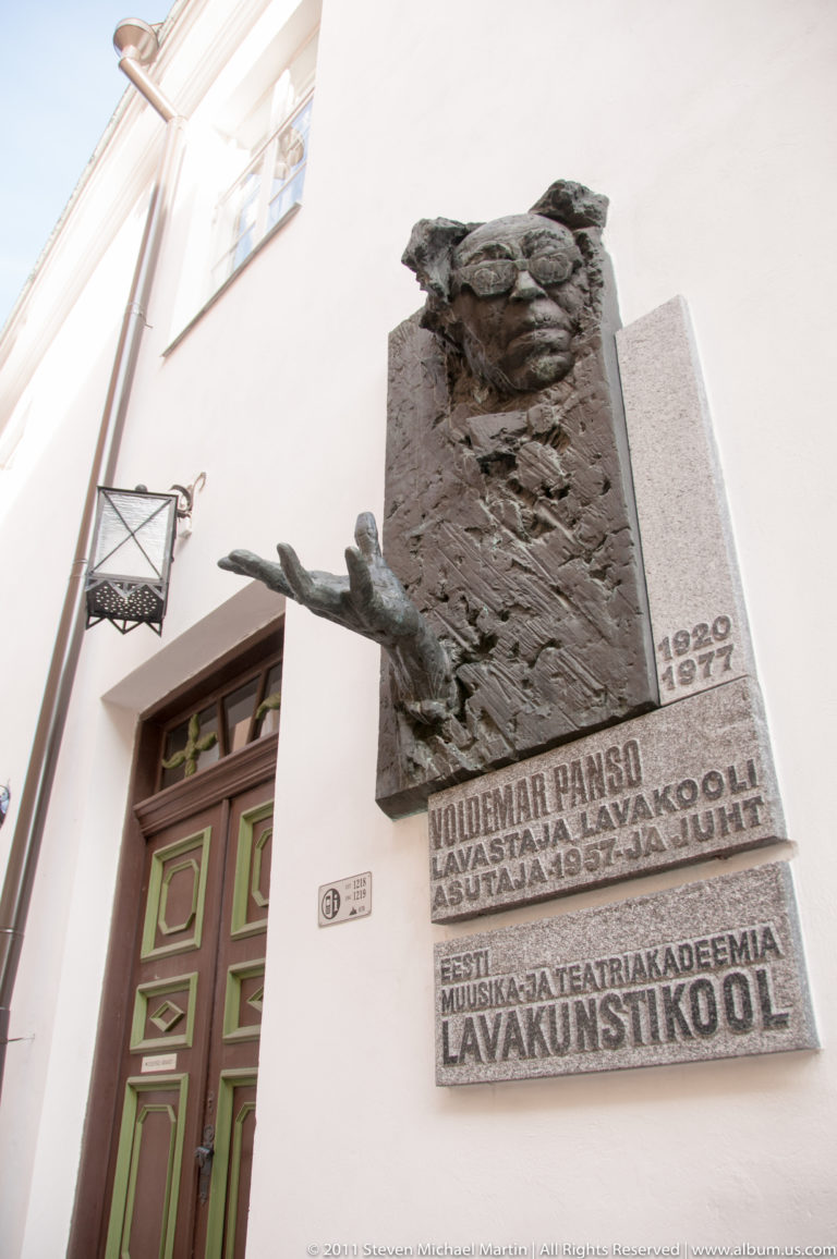 Voldemar Panso memorial plaque with relief portrait, projecting hand, dates 1920–1977, and Estonian Drama School inscription.