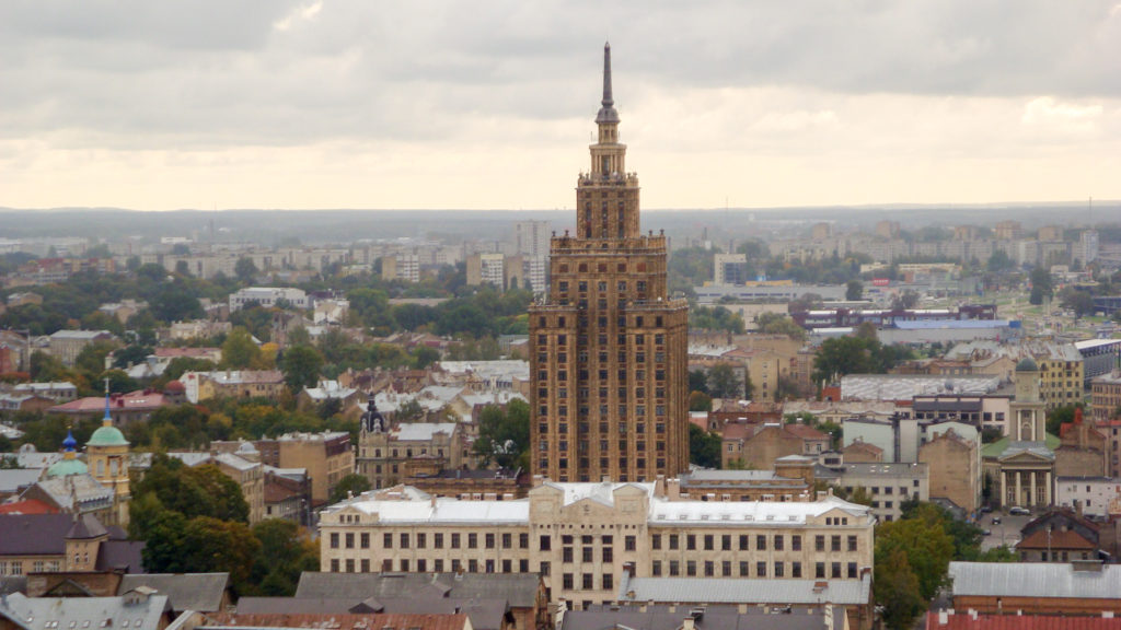 Latvian Academy of Sciences tower rising prominently above surrounding Riga neighborhoods in an elevated city view.
