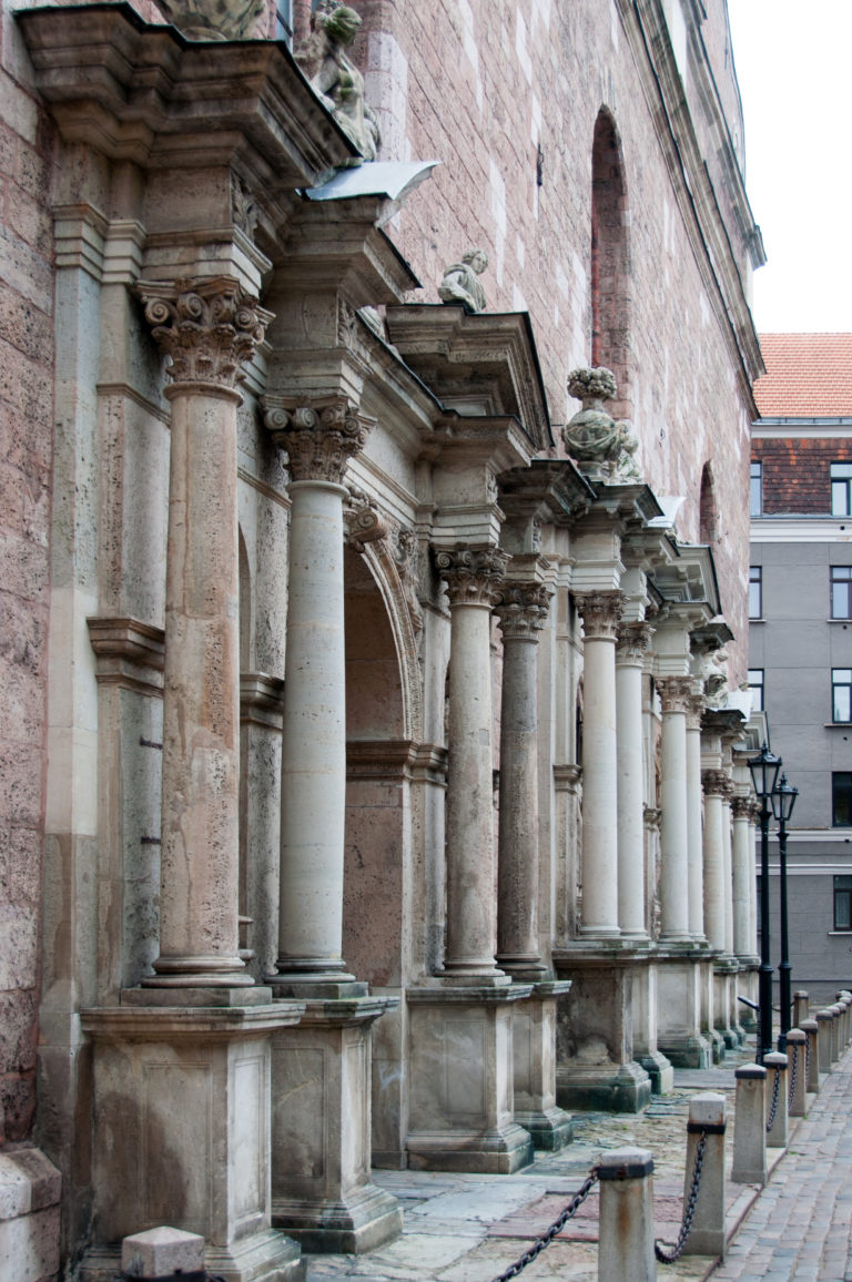Ornate stone entrance portals with paired columns and pediments along the brick wall of St. Peter’s Church.