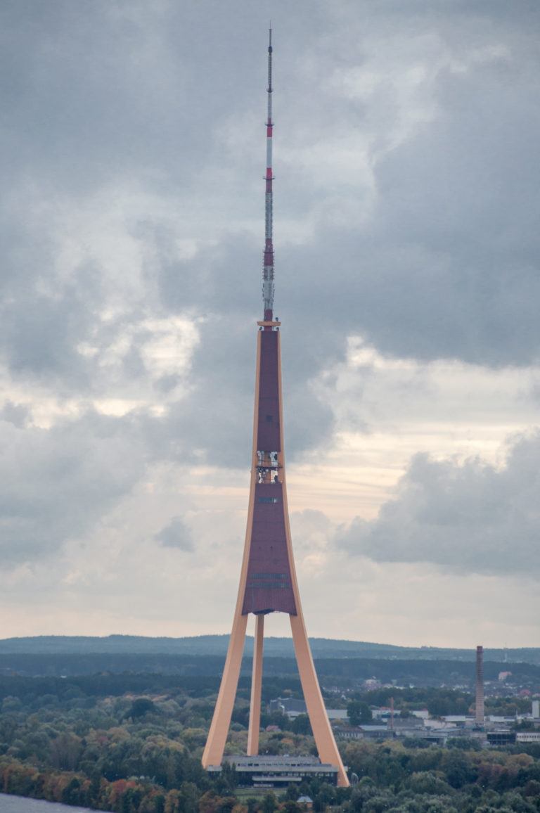 Riga Radio and TV Tower rising above trees with three splayed supports and a tall antenna mast.