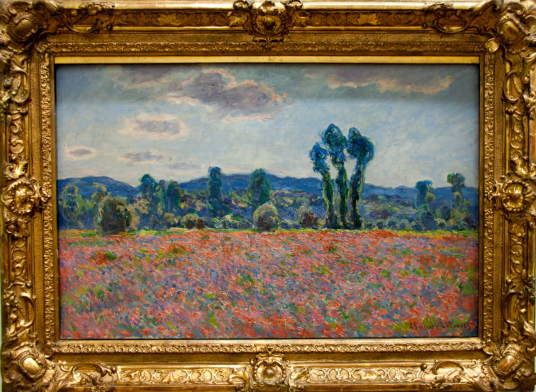 Claude Monet’s Poppy Field, with red poppies scattered across a meadow and a stand of tall trees beneath a cloudy sky.