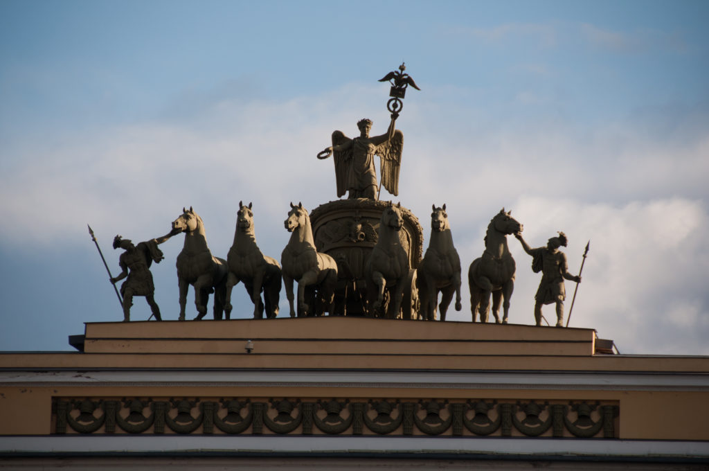 Bronze chariot group with winged central figure, horses, and flanking attendants atop the General Staff Building triumphal arch.