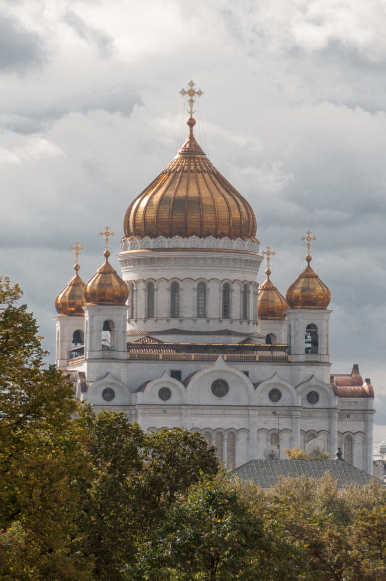Cathedral of Christ the Saviour rising above autumn trees, with one large gilded dome and four smaller domes.