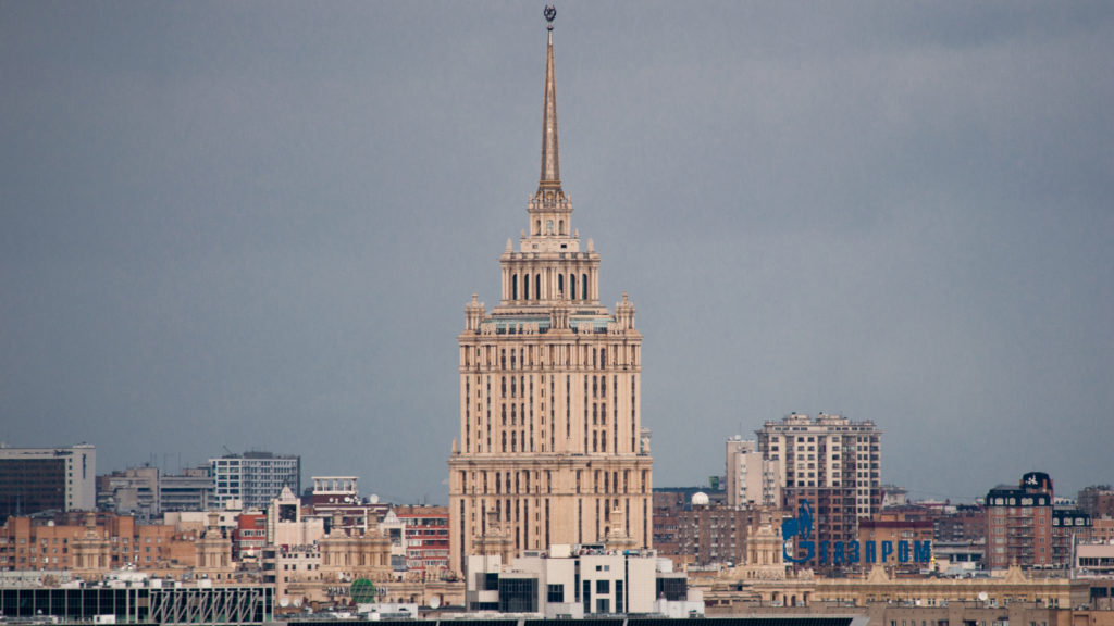 Hotel Ukraina Stalinist skyscraper with stepped crown and tall spire rising above Moscow beneath a gray sky.