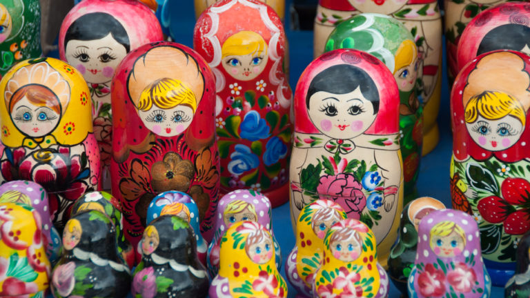 Rows of colorful matryoshka nesting dolls with floral patterns and painted faces at a Moscow souvenir stall.