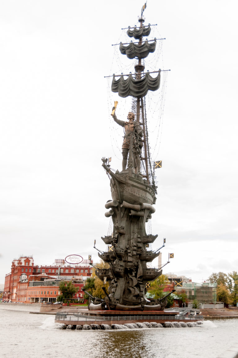 Full view of the Peter the Great Monument with stylized ship, tall mast, rigging, and fountain jets in the river.