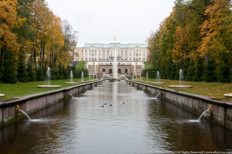 Sea Channel with ducks and side fountains leading toward the distant Grand Palace through autumn trees.