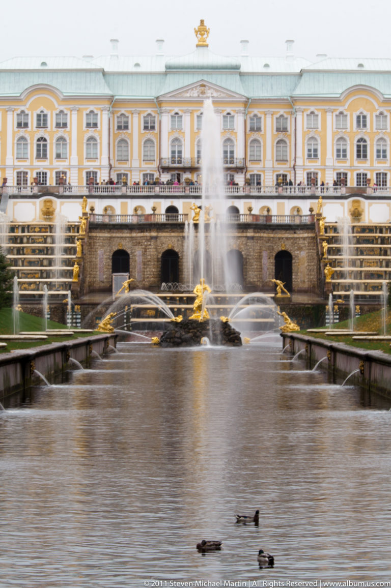 Grand Palace above the Grand Cascade and central fountain, with ducks on the foreground basin.