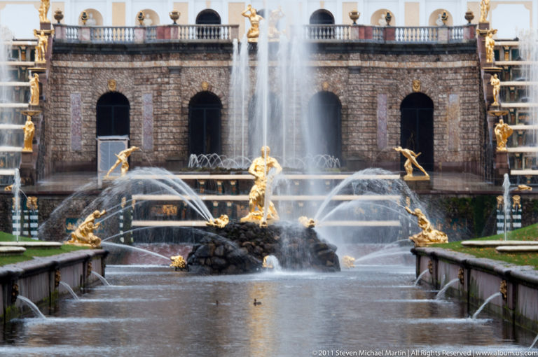 Central gilded fountain group amid crossing jets before the arched grotto of the Grand Cascade.