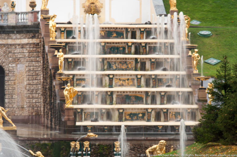 Stepped Grand Cascade with sheets of water, gilded figures, and dark decorated panels.
