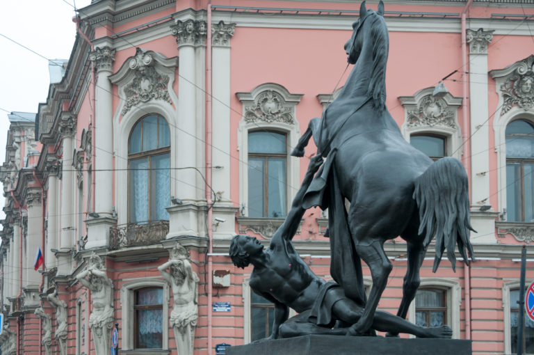 Rear view of bronze rearing horse and struggling male figure from Klodt’s Horse Tamers on Anichkov Bridge.