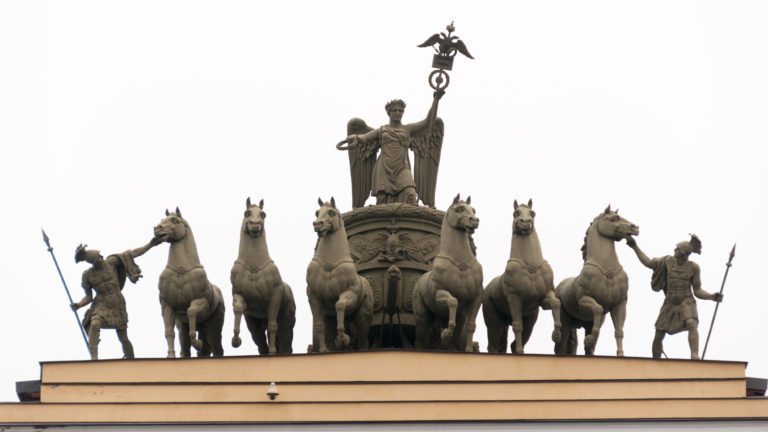 Bronze six-horse chariot with winged female figure and armed warriors atop the General Staff Building arch.