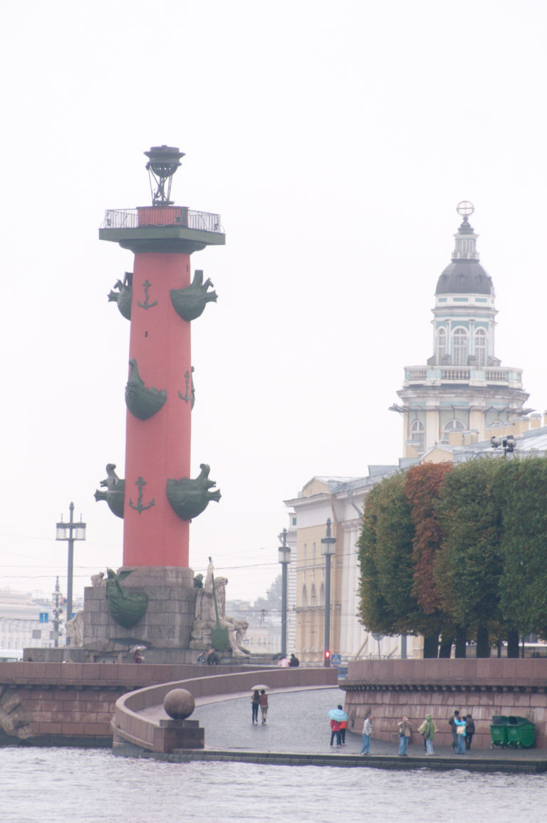 Red Rostral Column with projecting ship prows at left and the tower of the Kunstkamera rising in the background.