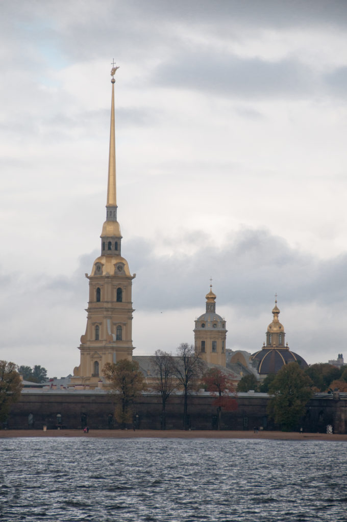 Peter and Paul Cathedral and surrounding fortress buildings across the Neva, with the gilded spire centered above the waterfront.