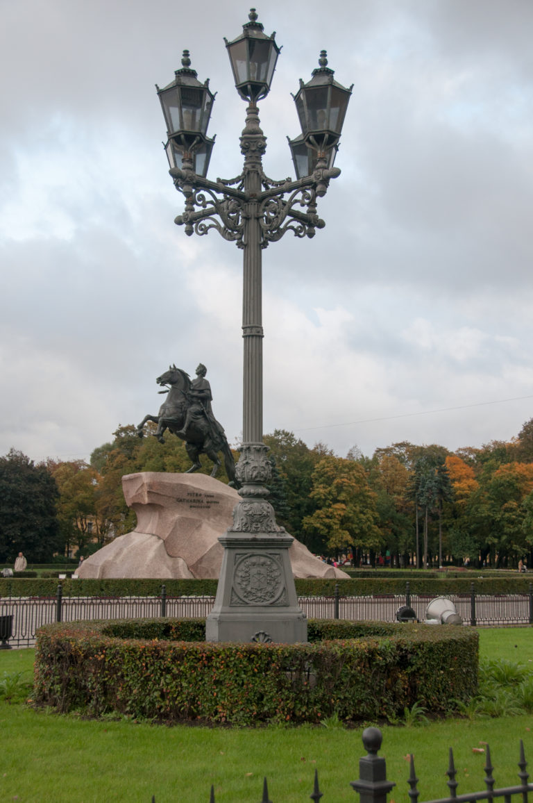 Large ornate streetlamp centered in Senate Square with the Bronze Horseman visible behind it to the left.