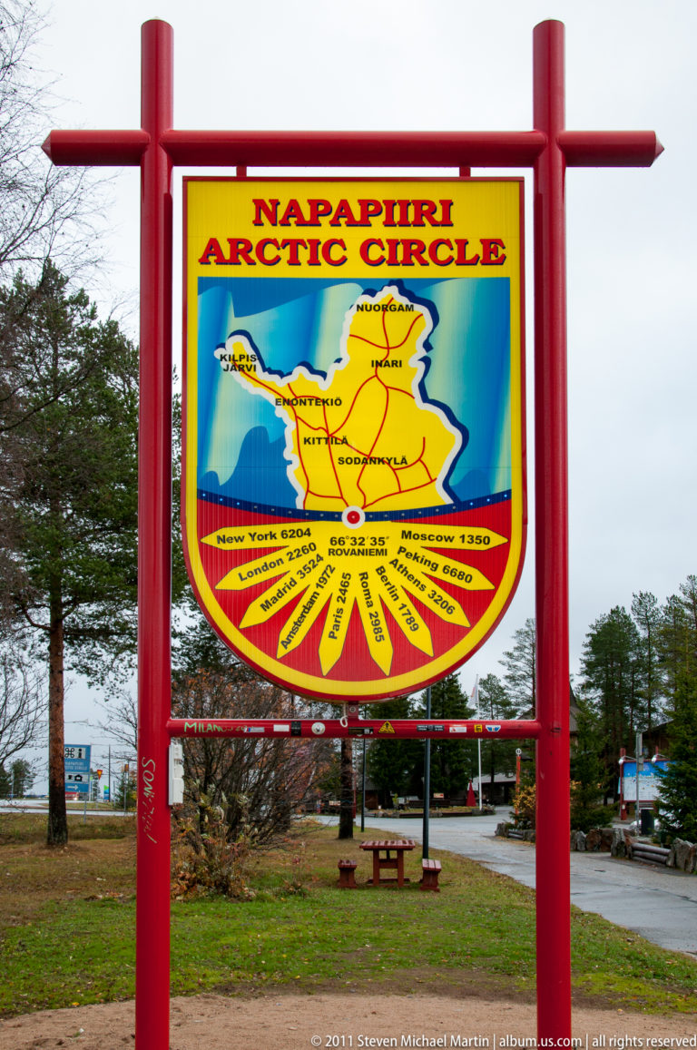 Colorful Napapiiri Arctic Circle map sign in a red frame, showing Finland, roads, and local destinations.