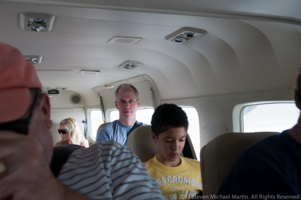 Passengers seated in the compact cabin of a small commuter aircraft in Belize.