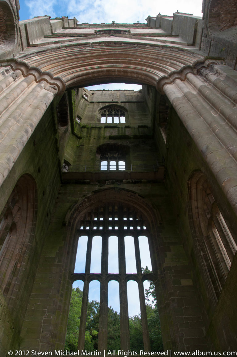 A roofless abbey structure rises around an open rectangle of sky.