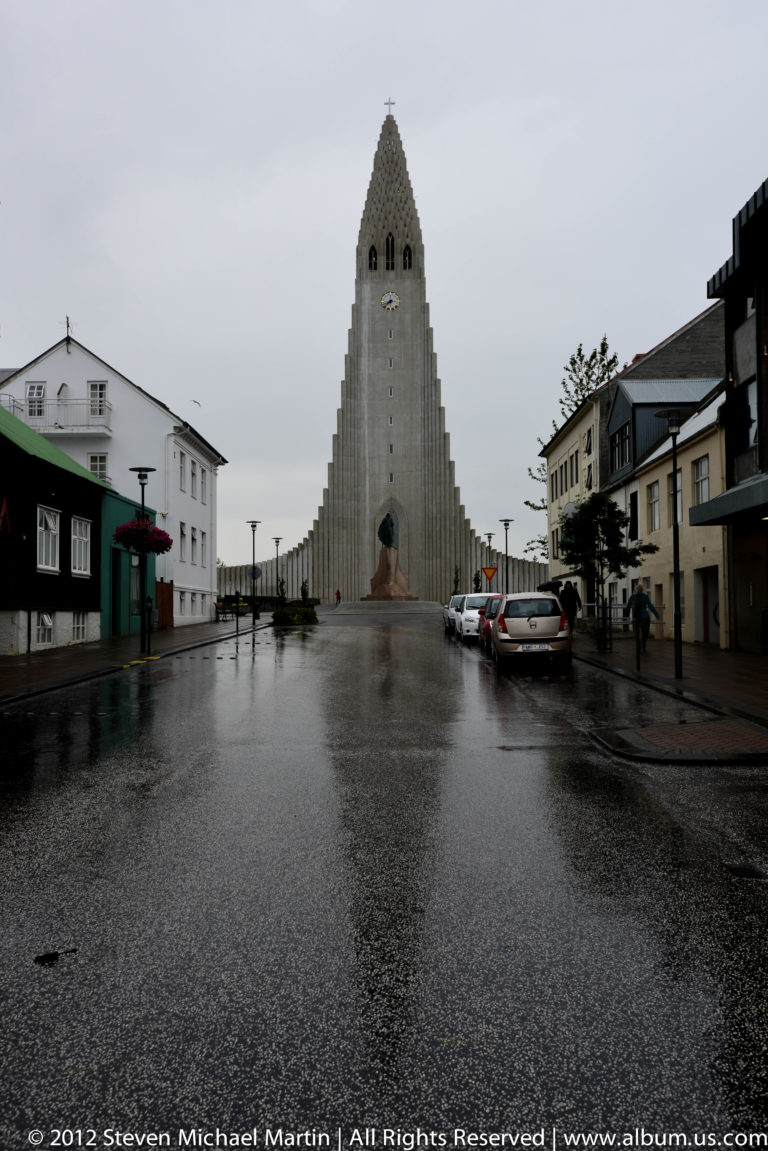 Hallgrímskirkja’s stepped concrete tower rising above a Reykjavík street.