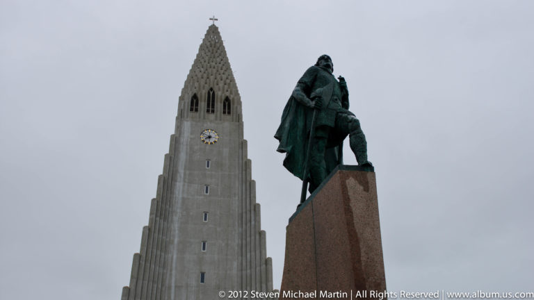 Leif Erikson statue on its stone plinth before the stepped tower of Hallgrímskirkja in Reykjavík.