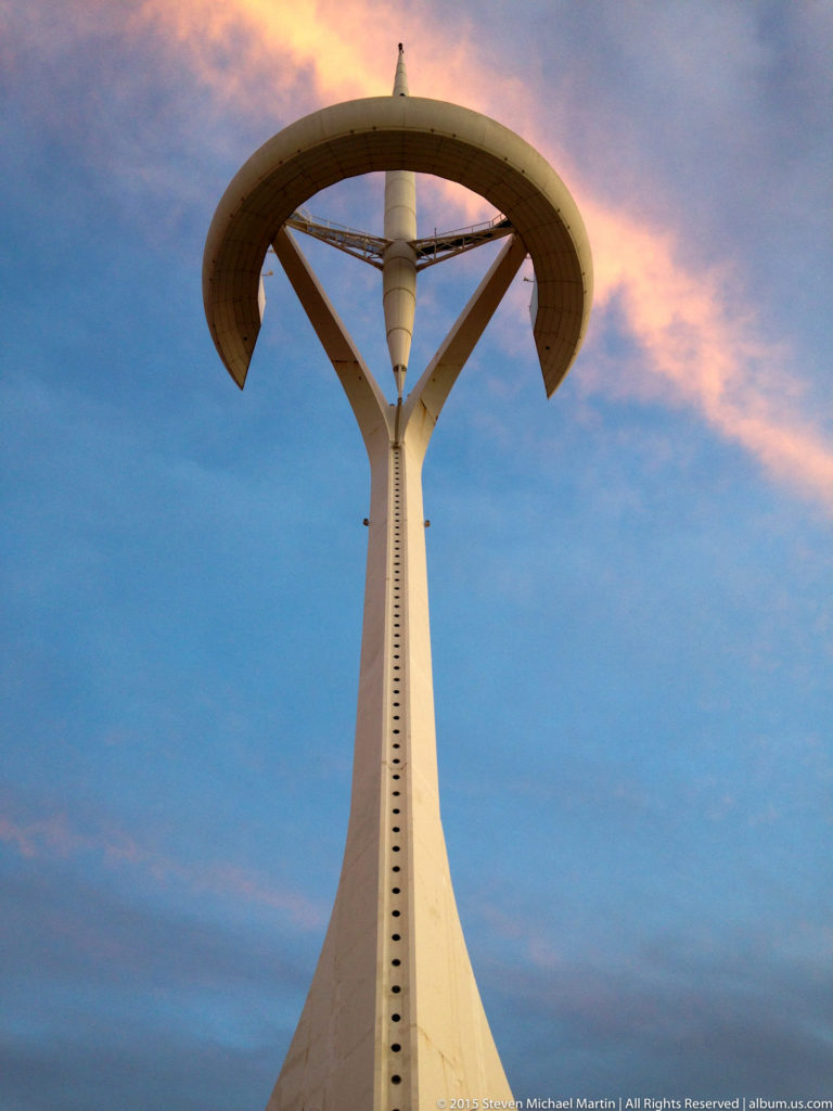 Montjuïc Communications Tower silhouetted against a pink and blue evening sky.