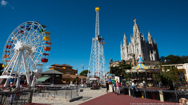 Ferris wheel, ride tower, and carousel with the Tibidabo basilica rising behind them.