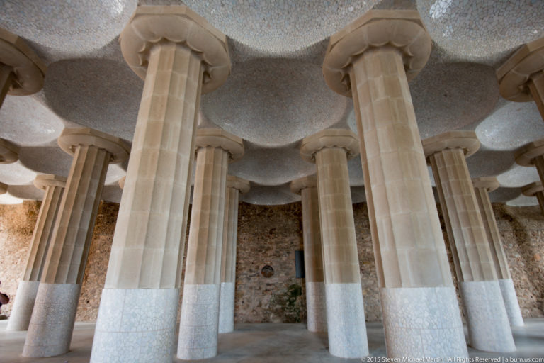 Rows of pale stone columns recede beneath the wavy tiled ceiling of Park Güell’s Hypostyle Room.