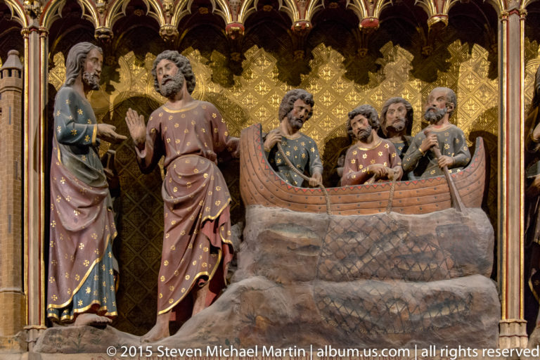 Painted Christ and disciples gathered beside a small sculpted boat beneath gilded Gothic arches.