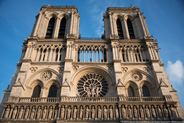 Upper west façade of Notre-Dame with twin towers, central rose window, galleries, and sculptural bands.