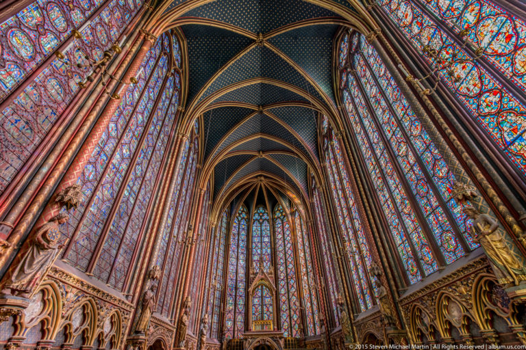 Upper chapel interior of Sainte-Chapelle, looking toward the apse through a soaring framework of slender colonnettes and stained-glass lancets.