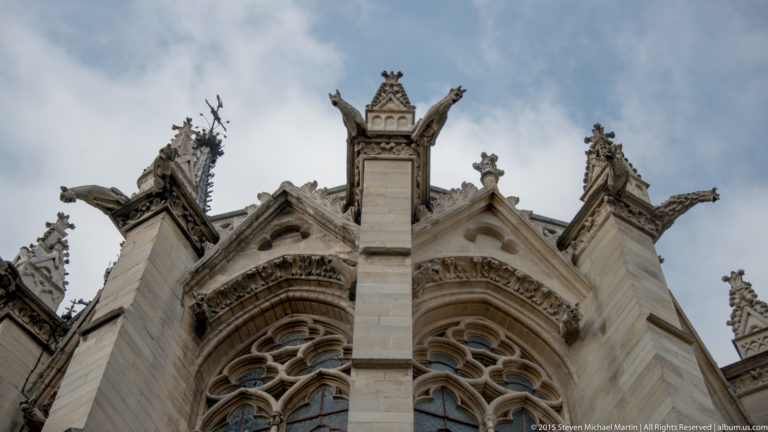 Exterior upper structure of Sainte-Chapelle with pointed window tracery, pinnacles, buttresses, and projecting gargoyles.