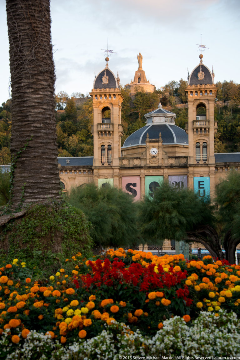 San Sebastián City Hall behind vivid flower beds and palms in the Alderdi Eder gardens.