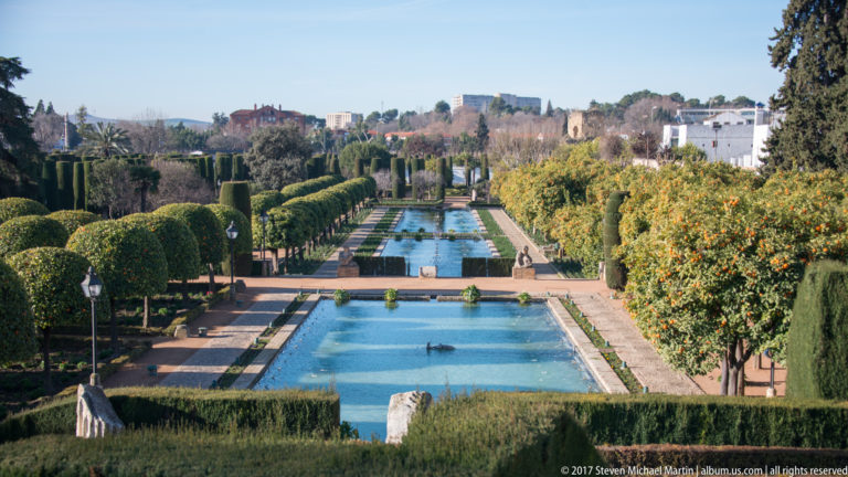 Long rectangular pools recede through clipped hedges and orange trees in the formal gardens of the Alcázar.