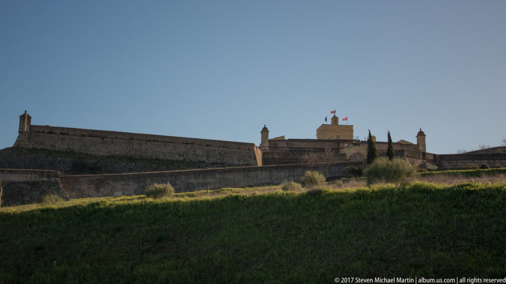 Low angular stone ramparts and bastions of the Fort of Santa Luzia, with flags flying above the central entrance area.