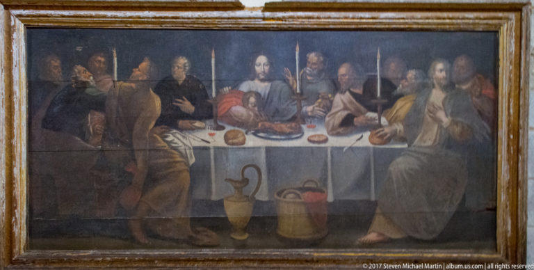 Framed Last Supper painting showing Christ and the apostles seated around a table with bread and vessels.