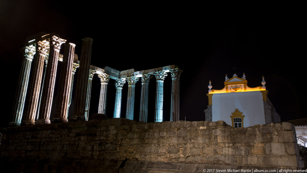 Floodlit Roman Temple of Évora at night with the nearby Igreja de São João Evangelista, or Igreja dos Lóios.