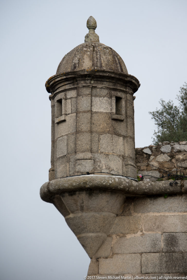 Round stone bartizan projecting from a fortified wall, with narrow openings and a shallow domed roof.