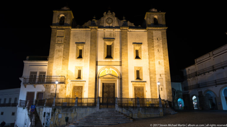 Floodlit Church of Santo Antão at night, with twin bell towers, central portal, and broad stone steps.